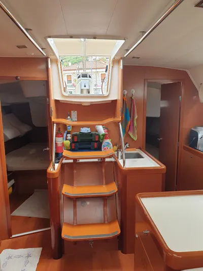  Yacht Photos Pics Interior of 2008 Beneteau Oceanis 50 sailboat, featuring wooden cabinetry and compact kitchen area.