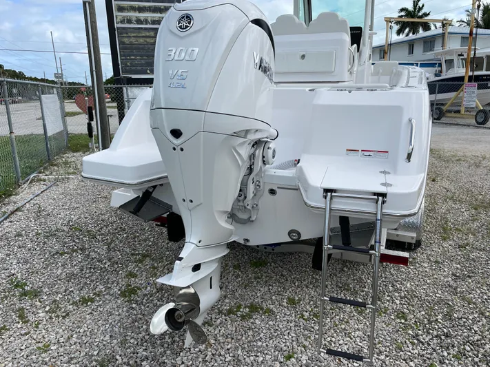 White Yacht Photos Pics 2023 Everglades 235CC boat with Yamaha 300 V6 engine, rear view on gravel.