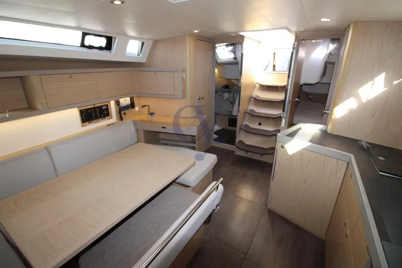 A Yacht Photos Pics Modern interior of 2018 Beneteau Oceanis 45 yacht, featuring spacious seating and wooden cabinetry.