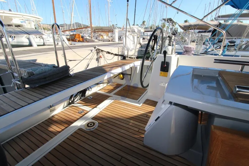 A Yacht Photos Pics 2018 Beneteau Oceanis 45 yacht cockpit with wooden deck and steering wheel in marina.