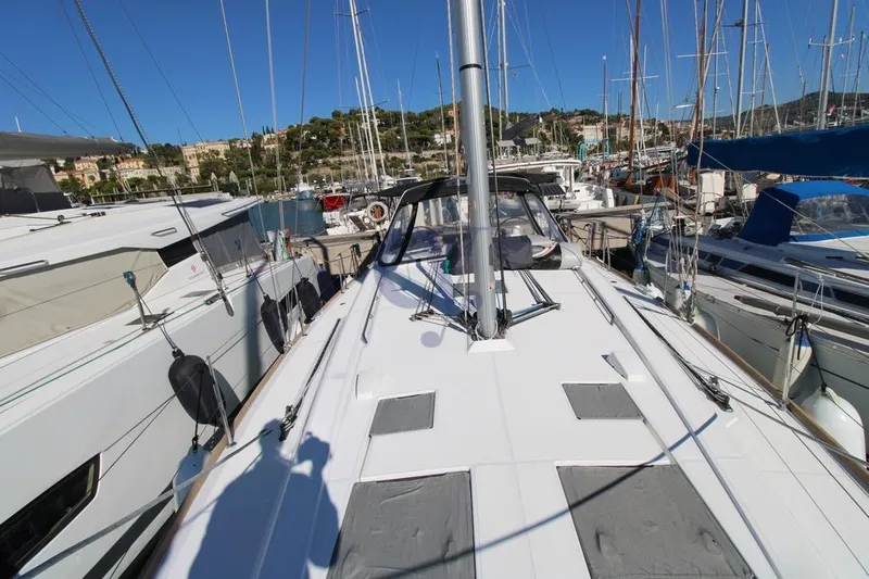 A Yacht Photos Pics 2018 Beneteau Oceanis 45 yacht docked in a marina, surrounded by other boats.