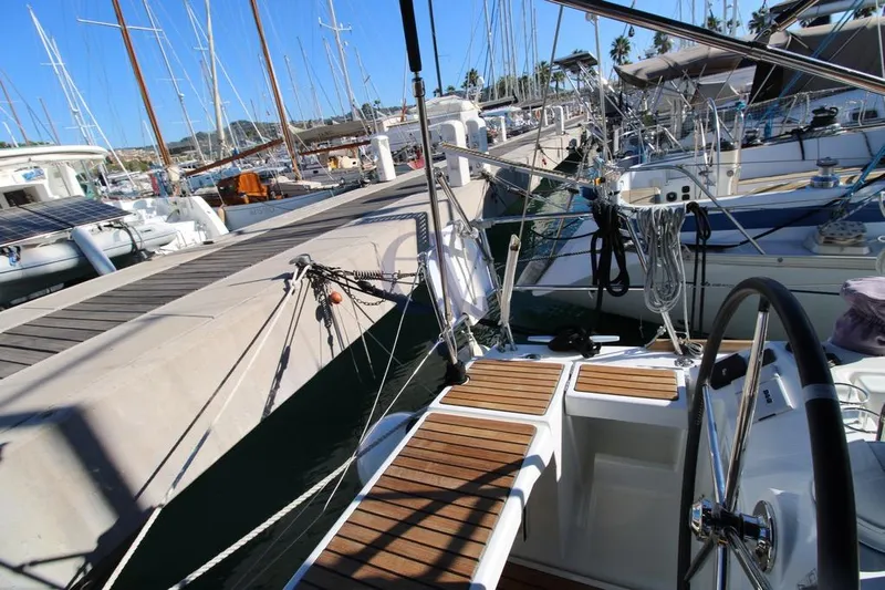 A Yacht Photos Pics Beneteau Oceanis 45 sailboat docked at marina, showcasing deck and steering wheel, 2018 model.
