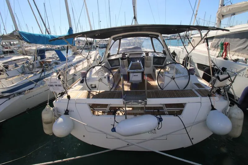 A Yacht Photos Pics 2018 Beneteau Oceanis 45 sailboat docked in marina, rear view with dual steering wheels.