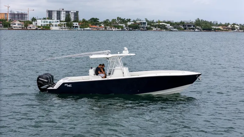  Yacht Photos Pics 2015 SeaVee 340Z boat cruising on a calm waterway near a coastal city.