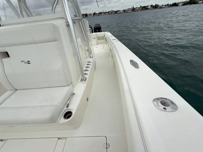  Yacht Photos Pics 2015 SeaVee 340Z boat deck with white seating, on calm water.