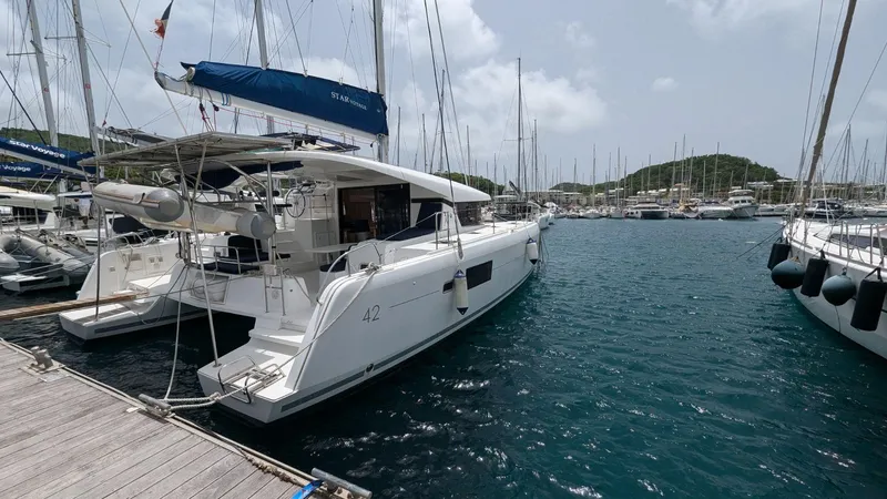 Mango IV Yacht Photos Pics 2017 Lagoon 42 catamaran docked at marina, surrounded by other boats.