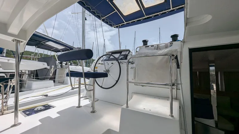 Mango IV Yacht Photos Pics Helm station of a 2017 Lagoon 42 catamaran with blue canopy and modern controls.