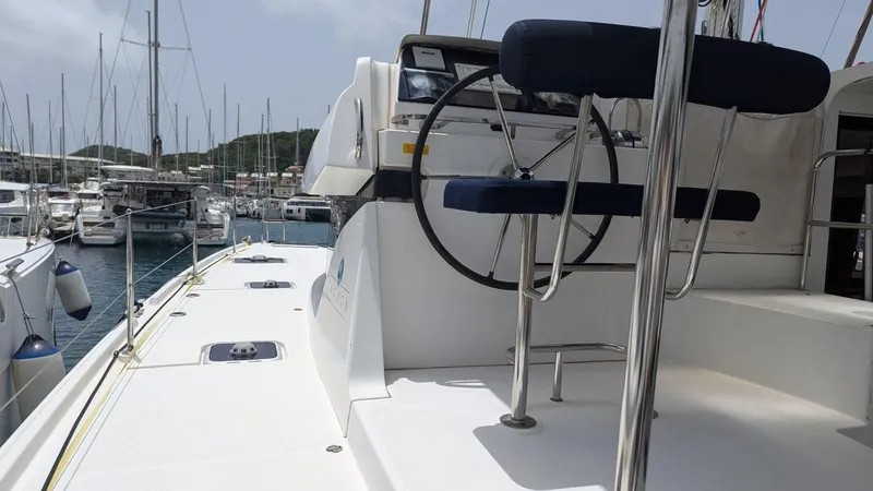 Mango IV Yacht Photos Pics 2017 Lagoon 42 catamaran docked in marina, featuring helm and seating area.