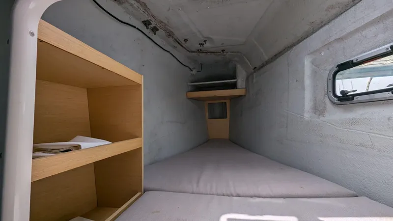 Mango IV Yacht Photos Pics Interior cabin of 2017 Lagoon 42 catamaran with wooden shelves and small window.