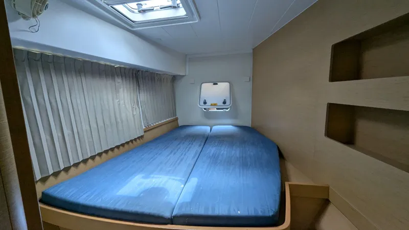 Mango IV Yacht Photos Pics Cozy cabin interior of 2017 Lagoon 42 catamaran with bed and window.