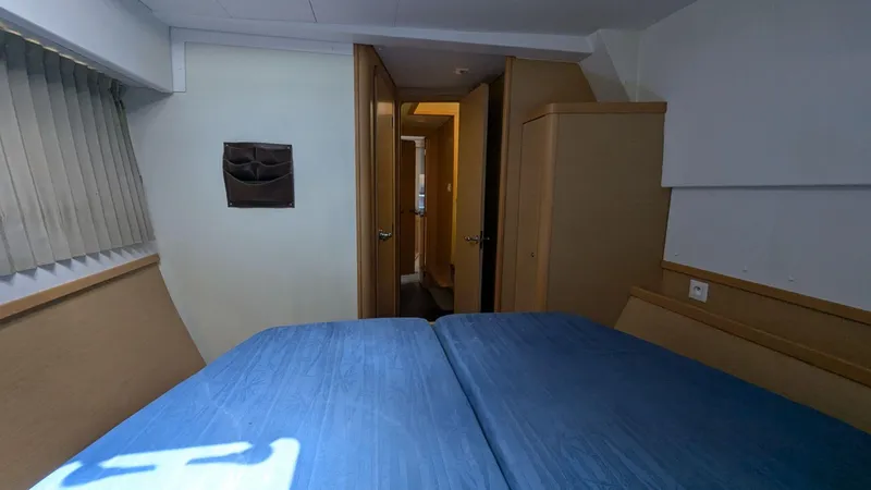 Mango IV Yacht Photos Pics Interior cabin of 2017 Lagoon 42 catamaran with blue bedding and wooden furnishings.