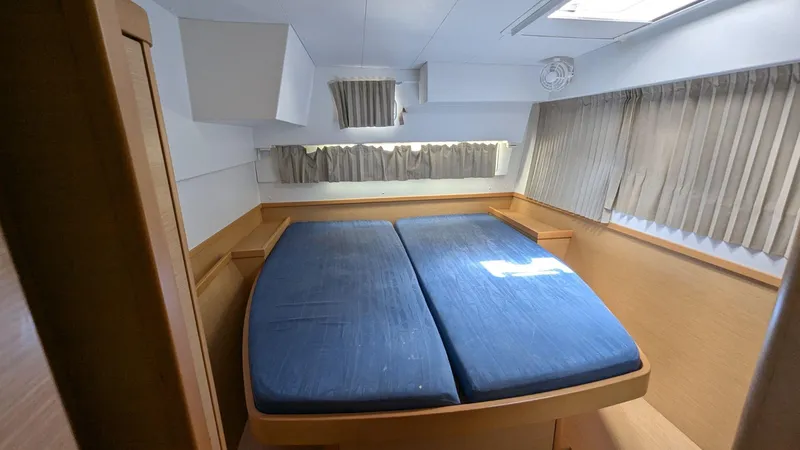 Mango IV Yacht Photos Pics Interior cabin of a 2017 Lagoon 42 catamaran with a double bed and curtains.