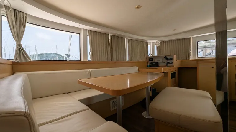 Mango IV Yacht Photos Pics Interior of 2017 Lagoon 42 catamaran with beige seating and wooden table.