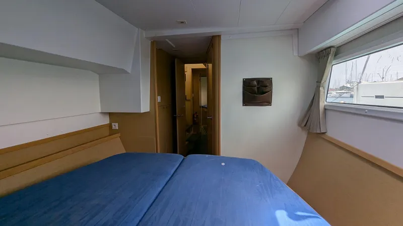 Mango IV Yacht Photos Pics Cabin interior of 2017 Lagoon 42 catamaran with blue bedding and window view.