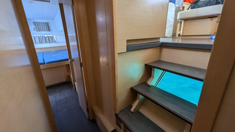 Mango IV Yacht Photos Pics Interior of 2017 Lagoon 42 catamaran, featuring wooden stairs and cozy cabin.
