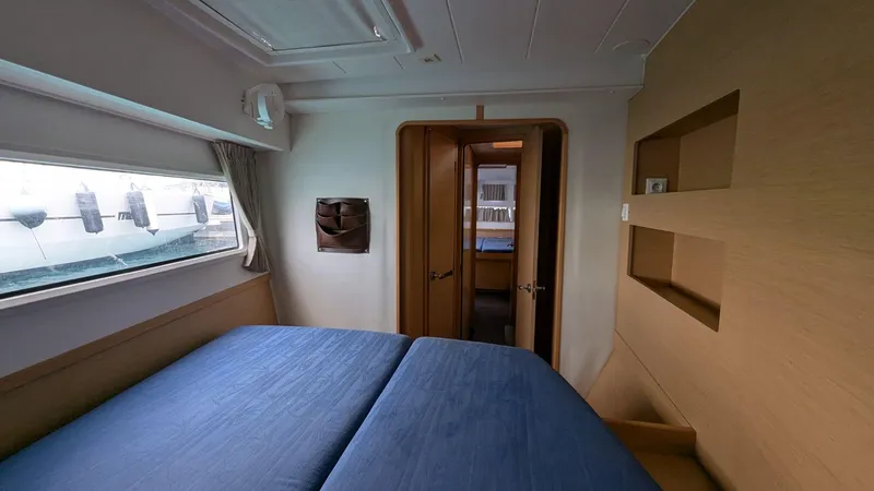 Mango IV Yacht Photos Pics Cabin interior of 2017 Lagoon 42 catamaran with blue bedding and wooden accents.