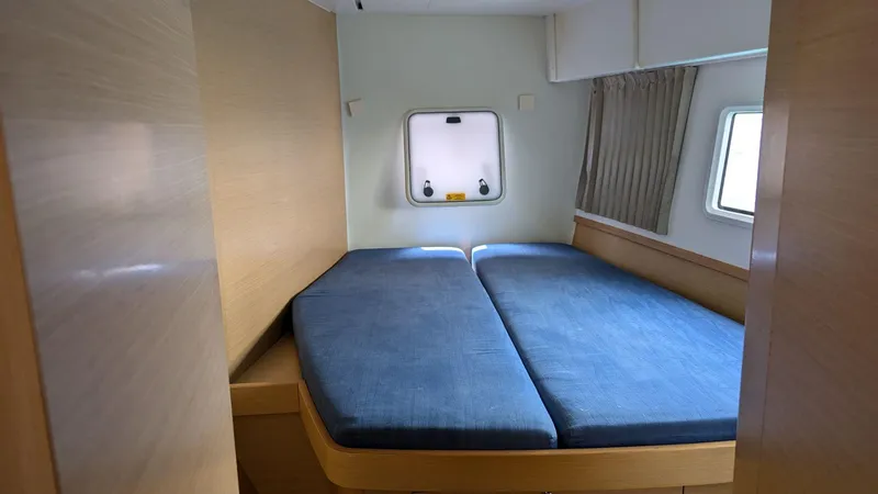 Mango IV Yacht Photos Pics Interior cabin of 2017 Lagoon 42 catamaran with blue bedding and wooden accents.