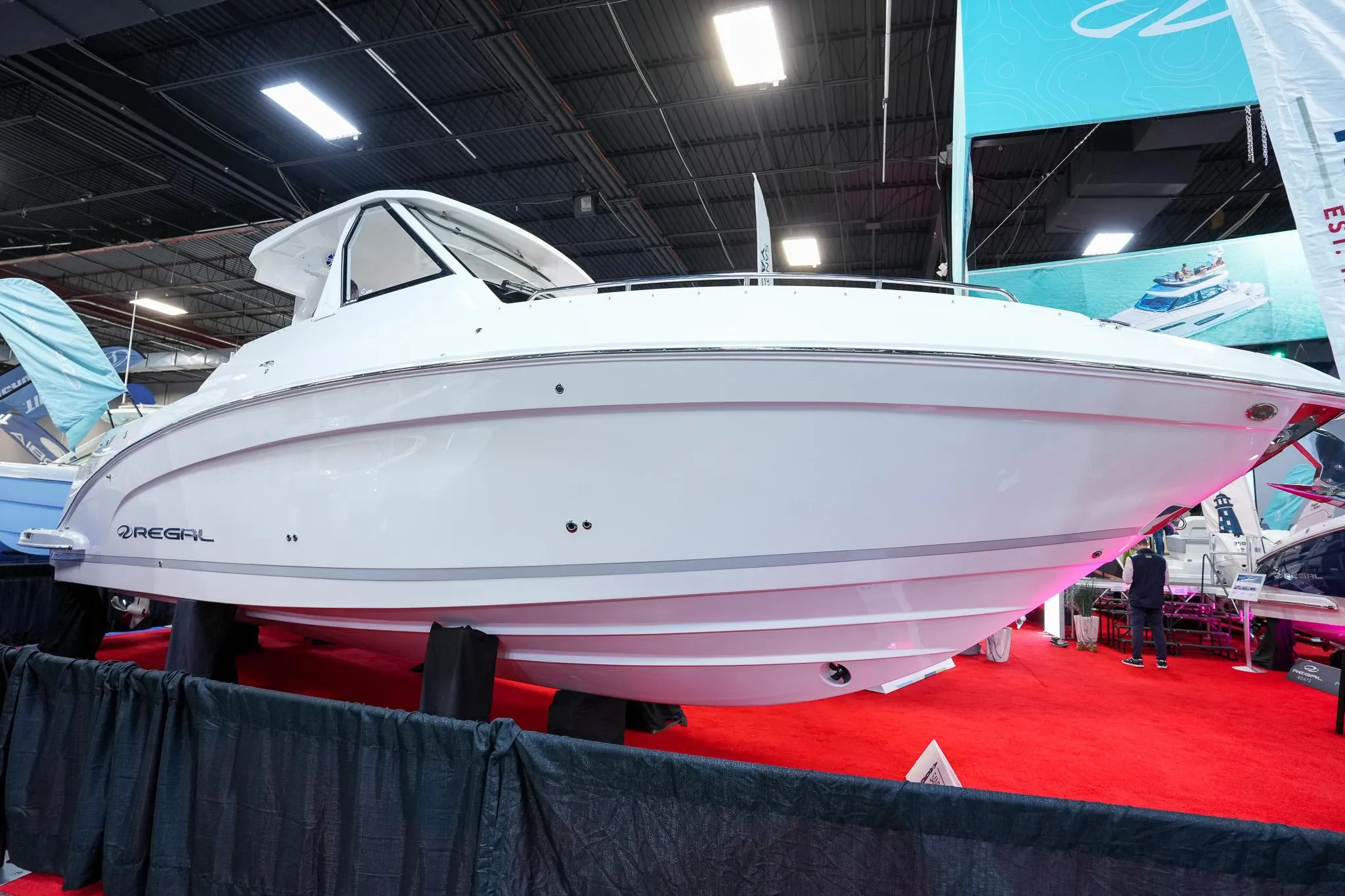 2025 Regal 33 SAV boat displayed at an indoor exhibition on a red carpet.