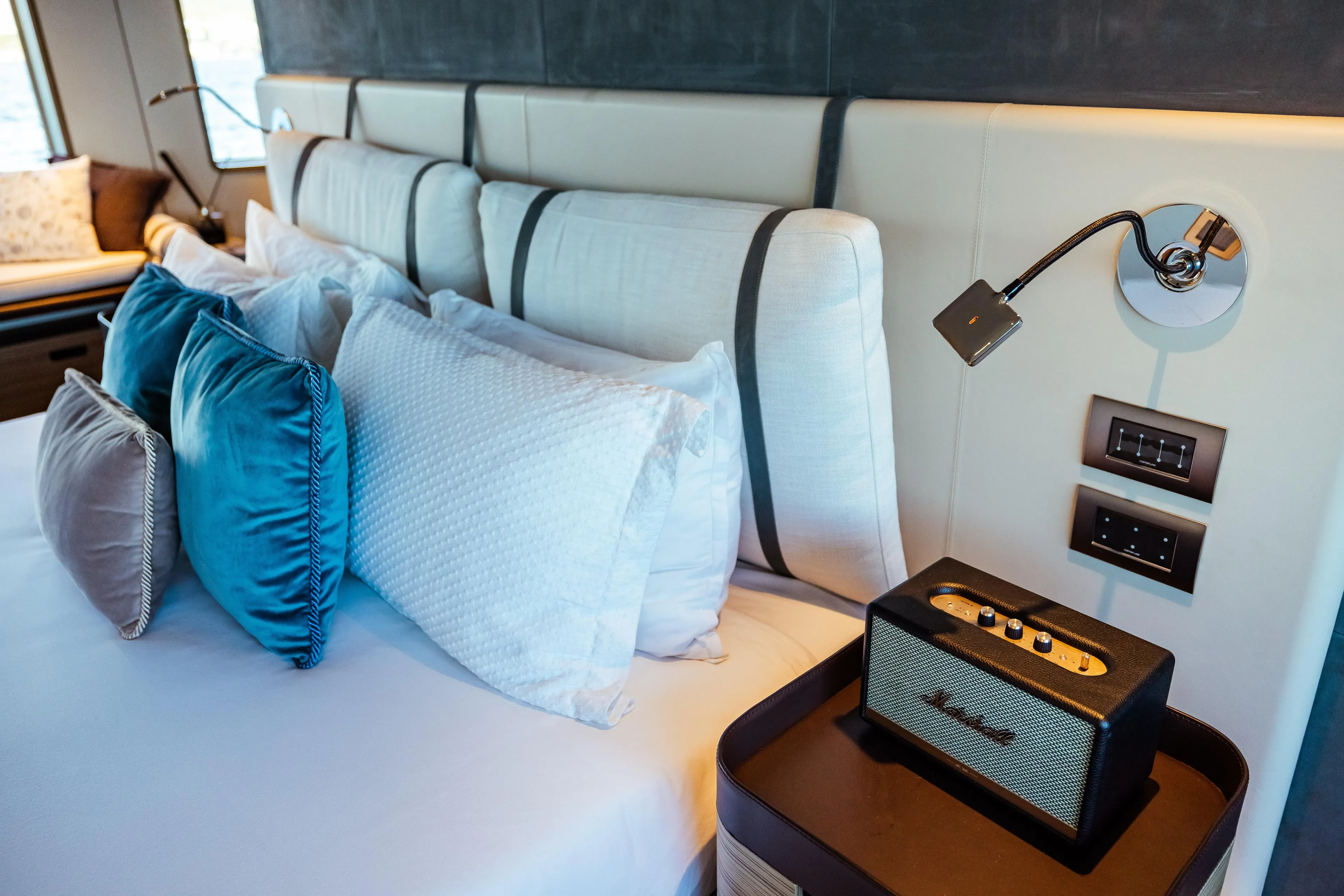 Luxurious bedroom interior on 2022 Custom Line Navetta 30 yacht with plush pillows and stylish decor.