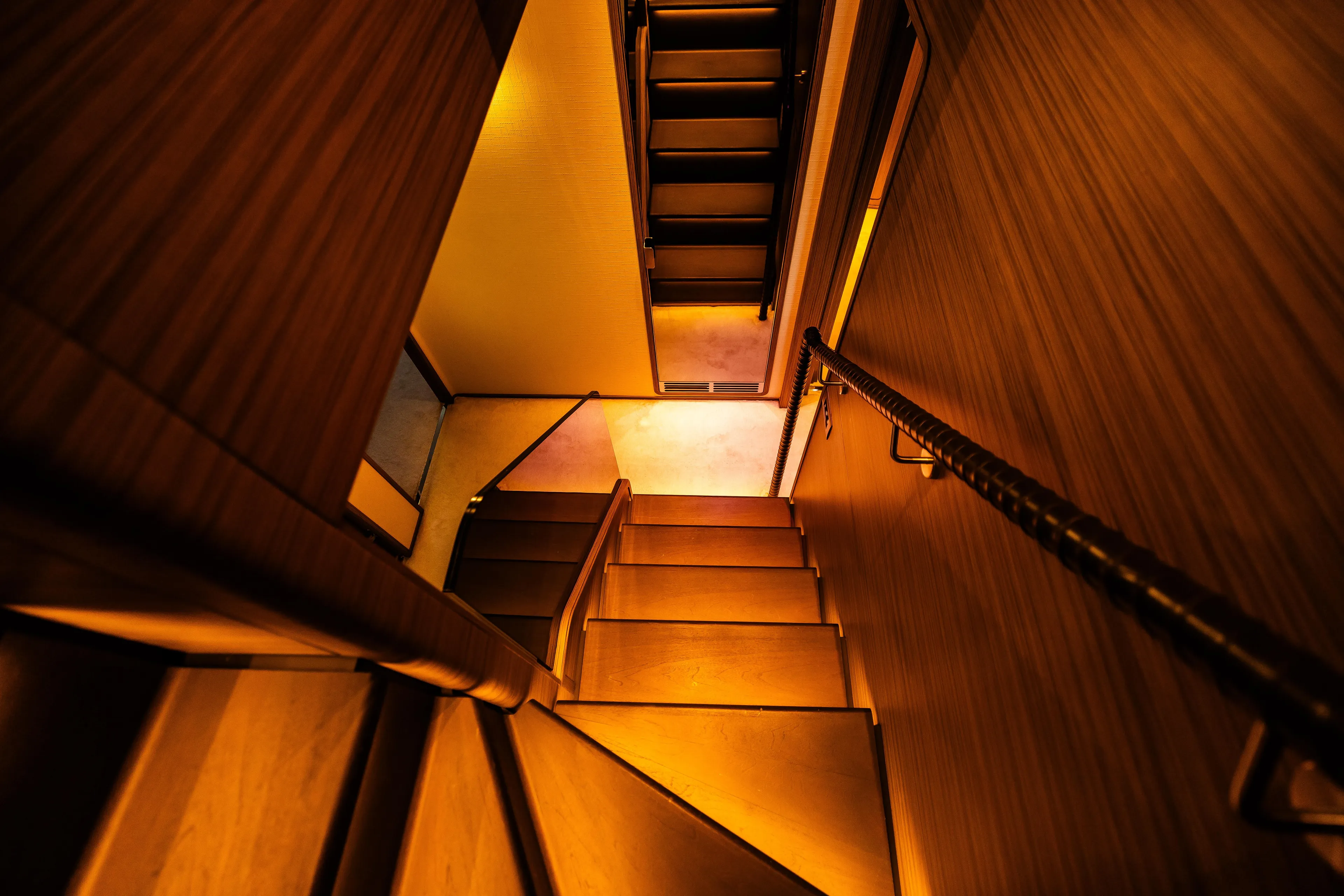 Warmly lit wooden staircase inside 2022 Custom Line Navetta 30 yacht.