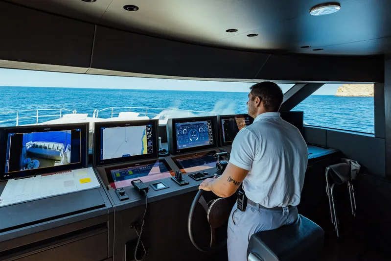  Yacht Photos Pics Man navigating Custom Line Navetta 30 yacht, 2022 model, with advanced control panels at sea.