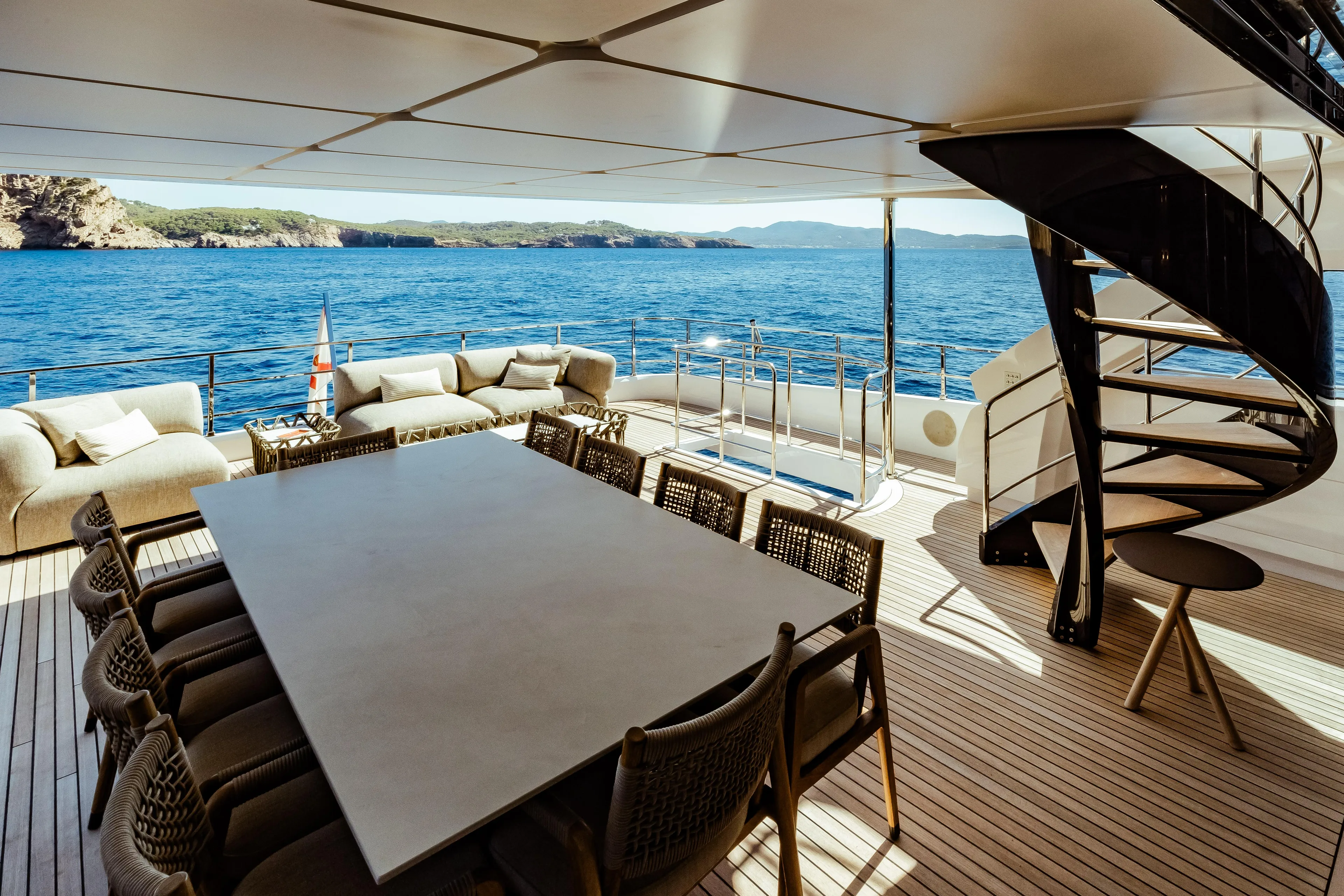 Luxurious 2022 Custom Line Navetta 30 yacht deck with elegant seating, dining area, and spiral staircase.