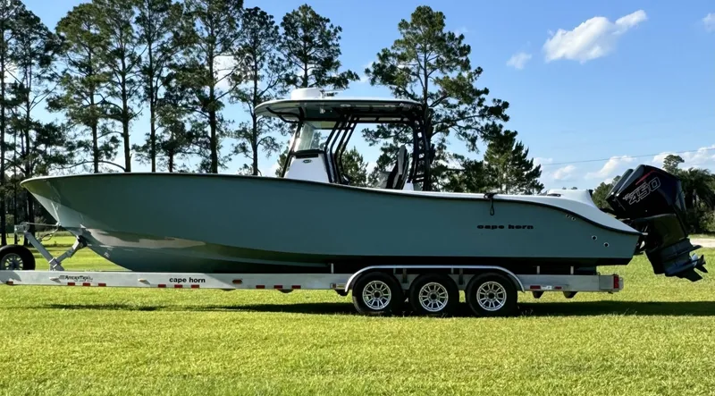  Yacht Photos Pics 2023 Cape Horn 34Xs boat on a trailer, side view, in a grassy area with trees in the background.