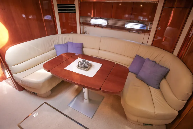  Yacht Photos Pics Luxurious 2008 Fairline Targa 52 GT yacht interior with curved leather seating and wooden table.