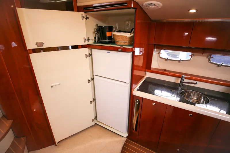  Yacht Photos Pics 2008 Fairline Targa 52 GT yacht kitchen with fridge, sink, and wooden cabinetry.