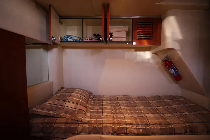  Yacht Photos Pics 2008 Fairline Targa 52 GT cabin with bed, storage, and fire extinguisher.