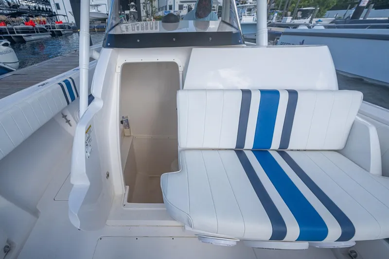 Match Point Yacht Photos Pics 2011 Intrepid 327 Center Console boat interior with striped seating and open storage compartment.