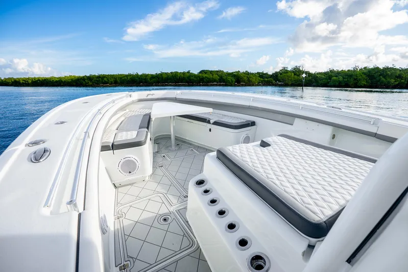  Yacht Photos Pics 2015 Yellowfin 42 Offshore boat interior with seating, on a calm water backdrop.