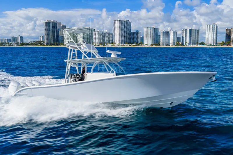  Yacht Photos Pics 2015 Yellowfin 42 Offshore boat cruising near city skyline on blue ocean waters.