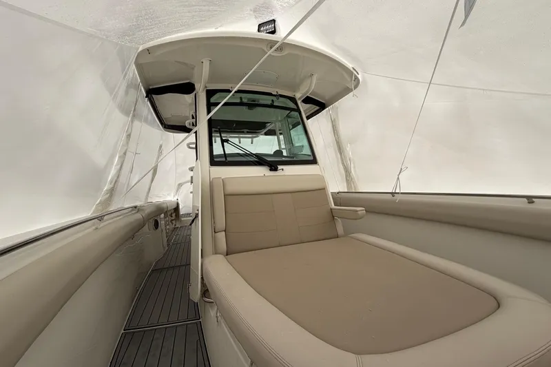  Yacht Photos Pics 2018 Boston Whaler 330 Outrage interior with beige seating under protective cover.