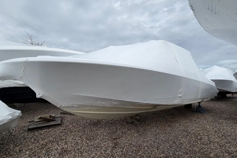  Yacht Photos Pics 2018 Boston Whaler 330 Outrage boat covered in protective wrap on gravel.
