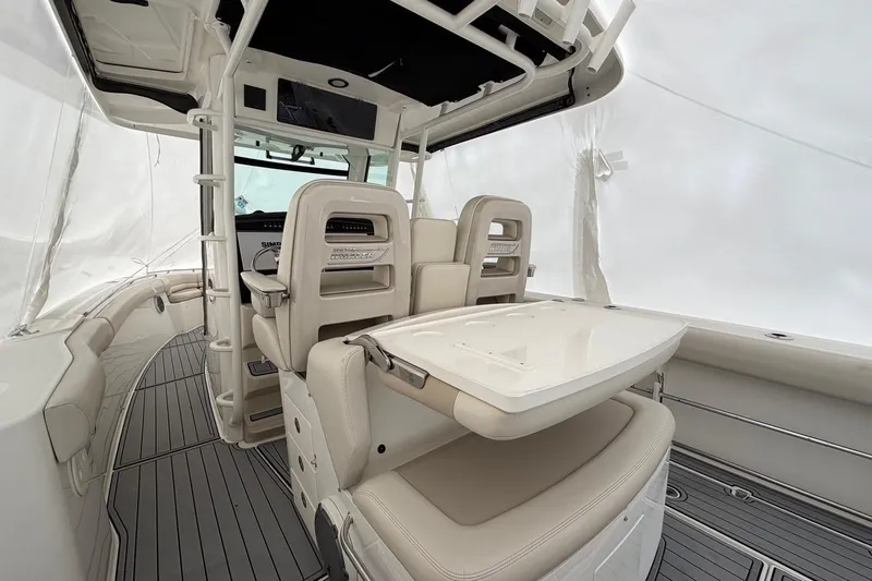  Yacht Photos Pics 2018 Boston Whaler 330 Outrage interior with seating and table, showcasing luxury design.
