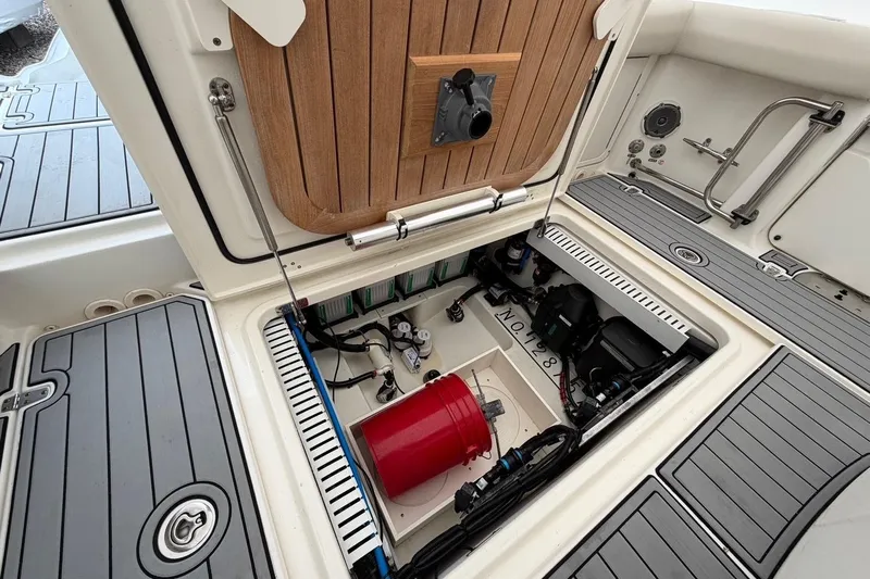  Yacht Photos Pics 2018 Boston Whaler 330 Outrage boat storage compartment with equipment and red bucket.