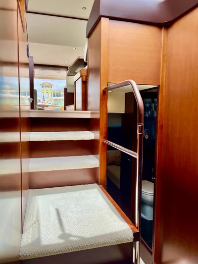  Yacht Photos Pics Interior staircase of 2015 Princess f56 yacht with wooden finish and carpeted steps.