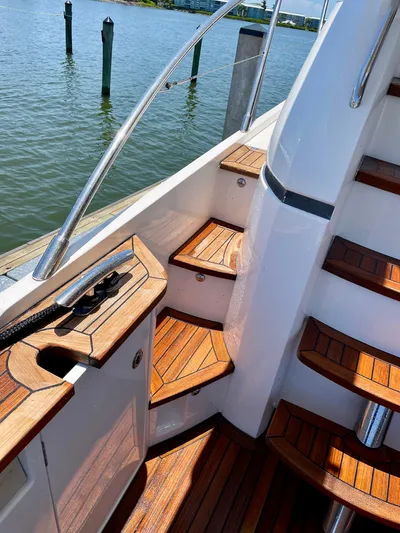  Yacht Photos Pics Staircase on 2015 Princess F56 yacht with wooden steps and railing, overlooking water.