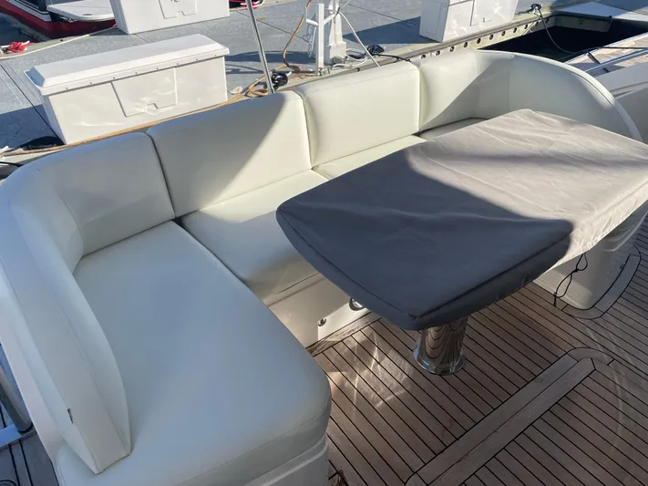  Yacht Photos Pics Luxurious seating area on 2015 Princess f56 yacht with covered table and white cushions.