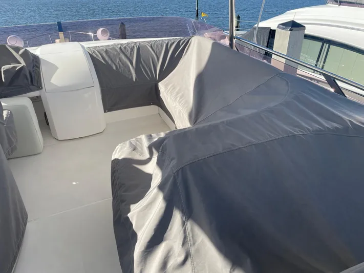  Yacht Photos Pics Covered seating area on a 2015 Princess f56 yacht, docked by the water.