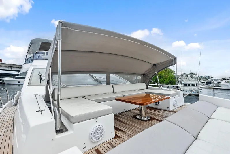 Class Dismissed Yacht Photos Pics 2017 Azimut 72 Flybridge yacht with shaded seating area and wooden table.
