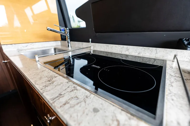 Class Dismissed Yacht Photos Pics Modern kitchen in 2017 Azimut 72 Flybridge yacht with sleek stovetop and sink.