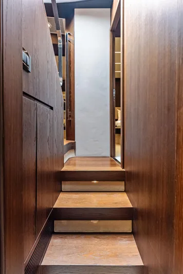 Class Dismissed Yacht Photos Pics Wooden staircase inside 2017 Azimut 72 Flybridge yacht, leading to interior cabin.