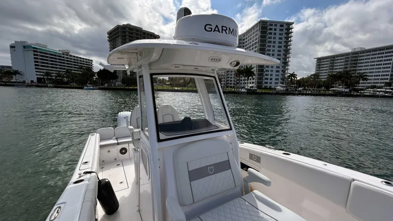  Yacht Photos Pics 2024 Sea Fox 268 Commander boat on water, cityscape background, overcast sky.