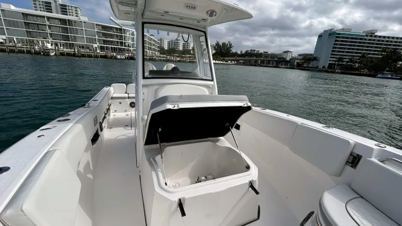  Yacht Photos Pics 2024 Sea Fox 268 Commander boat interior with open storage compartment, docked near modern buildings.