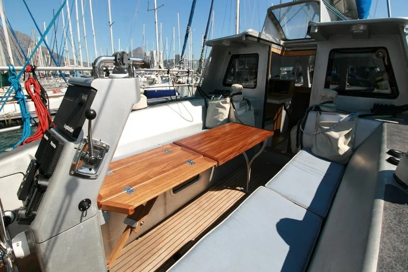 Gabsi Yacht Photos Pics Luxurious 2022 Custom Southwell 51 yacht interior with wooden table and cushioned seating in marina.