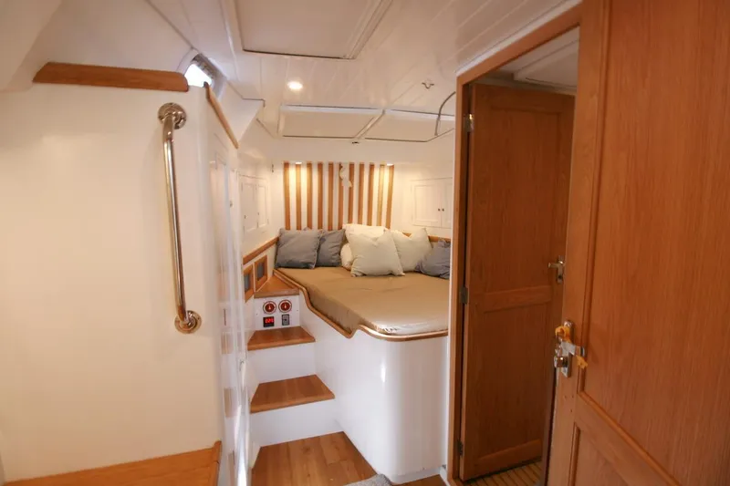 Gabsi Yacht Photos Pics Luxurious cabin interior of 2022 Custom Southwell 51 yacht with cozy bed and wooden accents.
