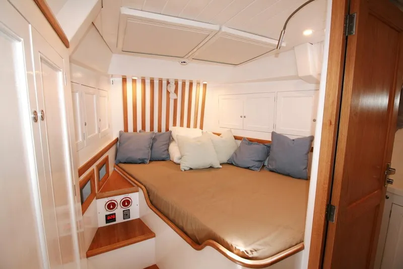 Gabsi Yacht Photos Pics Cozy cabin interior of 2022 Custom Southwell 51 yacht with plush bedding and wooden accents.
