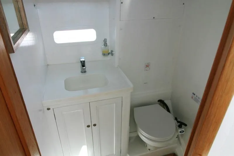 Gabsi Yacht Photos Pics Compact bathroom in 2022 Custom Southwell 51 boat, featuring sink and toilet.